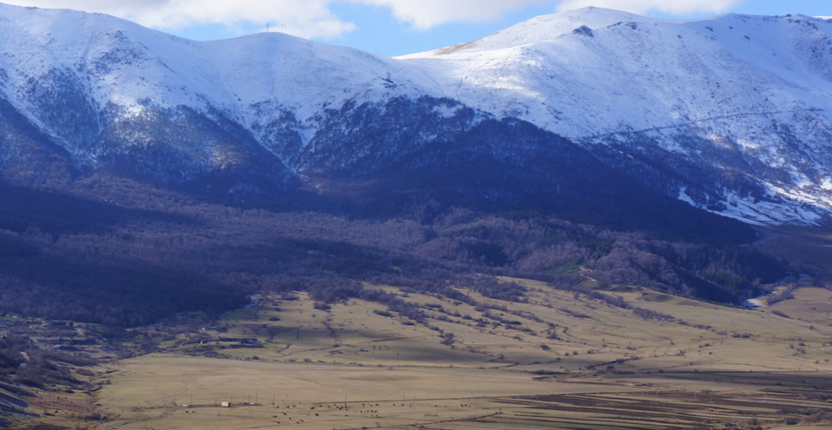 Armenia-Fields surrounded by snow-covered mountains